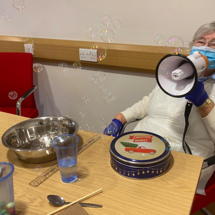 Starostnica z megafonom v domu za osebe z demenco.